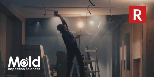 A person stands on a ladder conducting a mold assessment on the ceiling in a dimly lit construction site. They're using a handheld tool. The Mold Inspection Sciences logo is at the bottom left, and a red R logo is at the top right, marking the thorough investigation in progress.